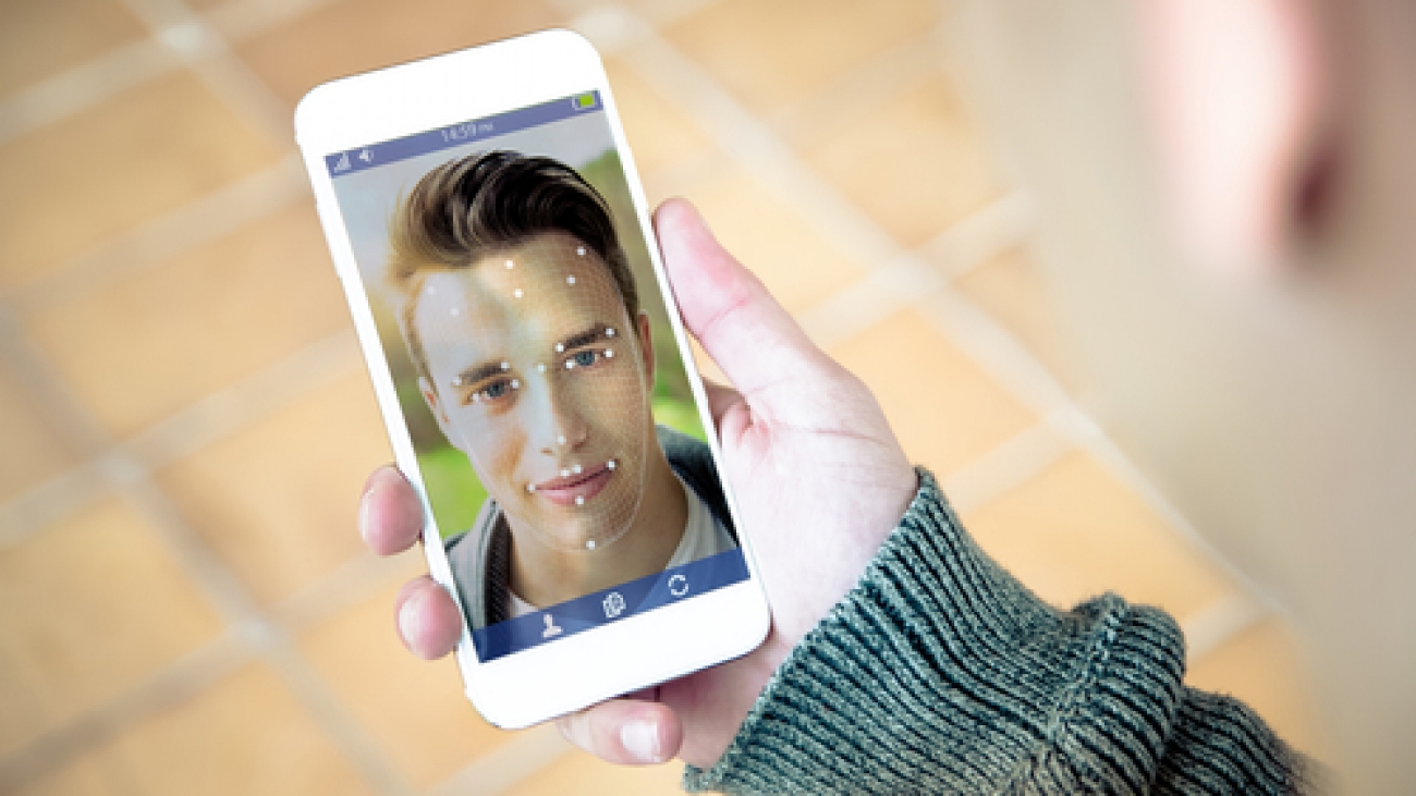 millennial using face id technology on smartphone