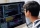 Smart teenage boy in glasses checking programming code on computer screen when sitting at his desk